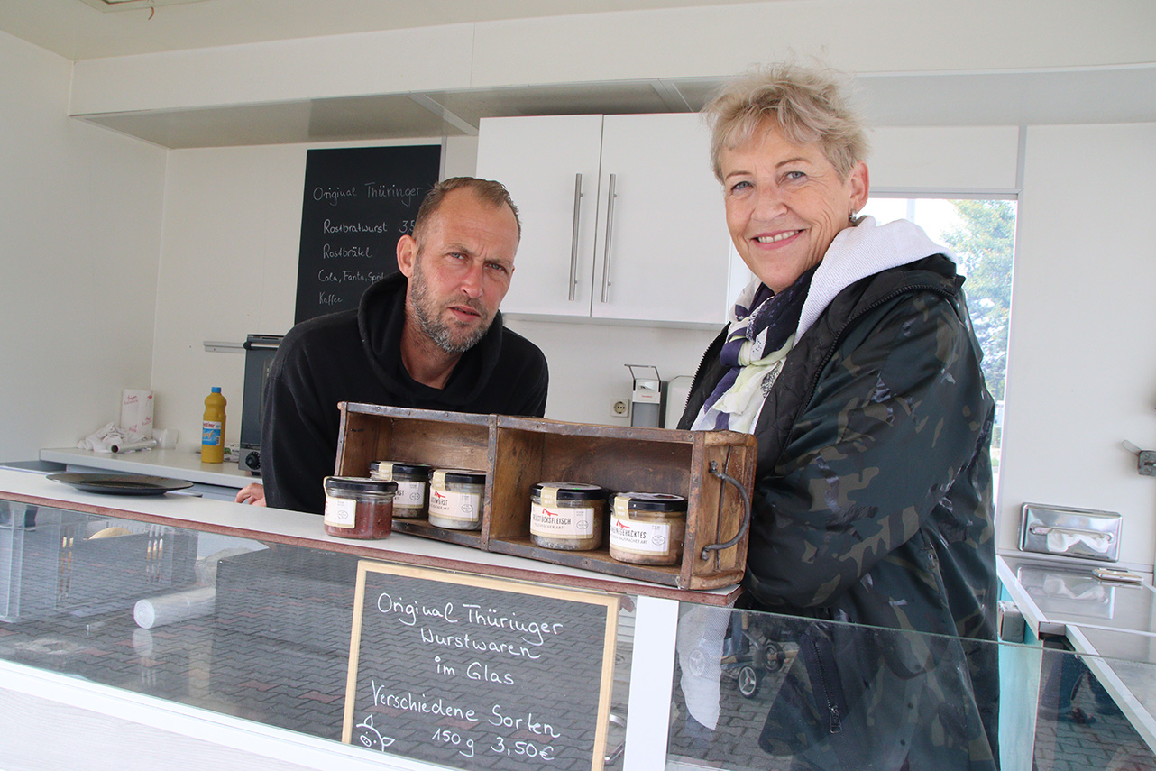 Ein Mann und eine Frau vom Bratwurstbub in ihrem Verkauswagen